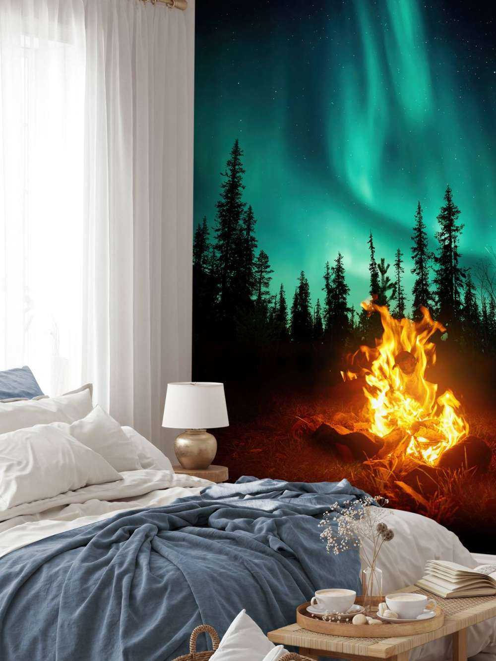 Fogata bajo la aurora boreal