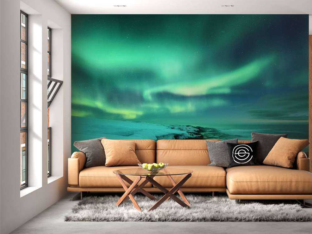 Aurora boreal verde sobre rocas nevadas