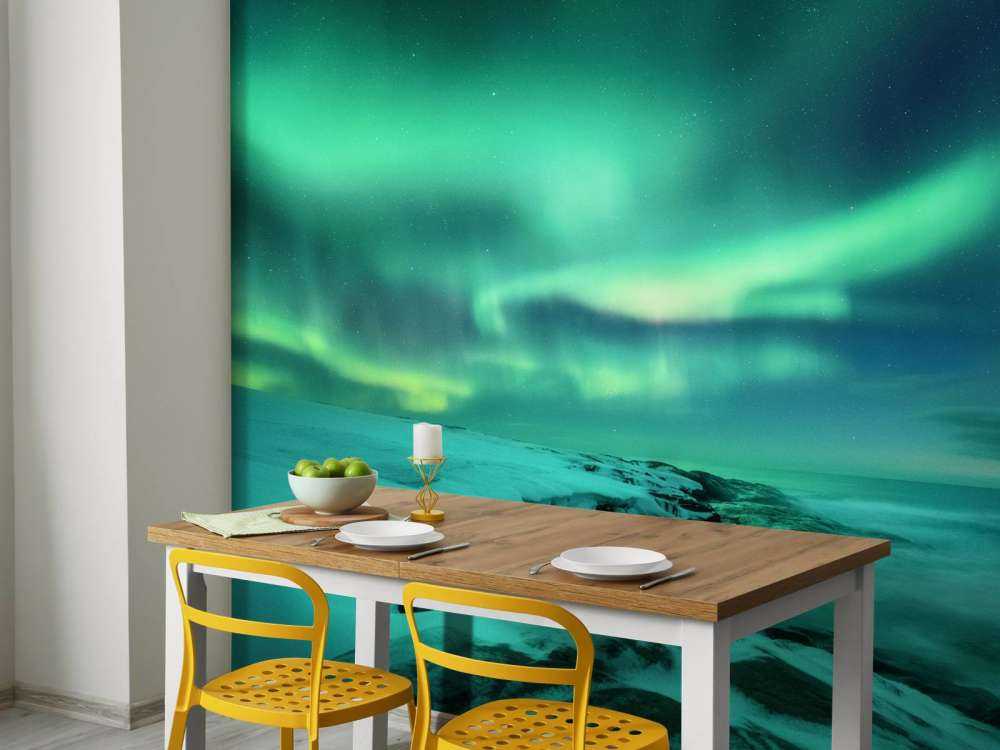 Aurora boreal verde sobre rocas nevadas